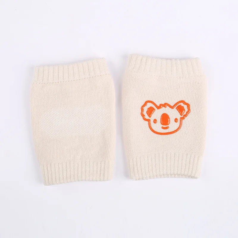 Non-slip baby knee pad in pink cotton with smiley face design, stacked with colorful pads for toddler protection during crawling.