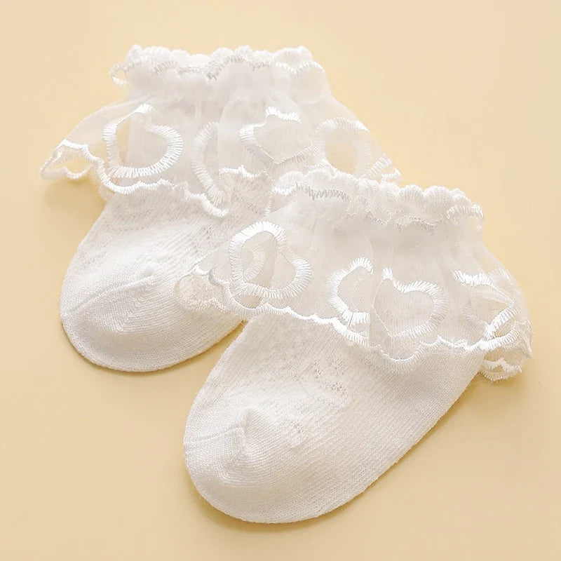 Lace baby girl socks in white with floral embroidery, made from soft combed cotton. Elegant princess-style socks for ages 0-8.