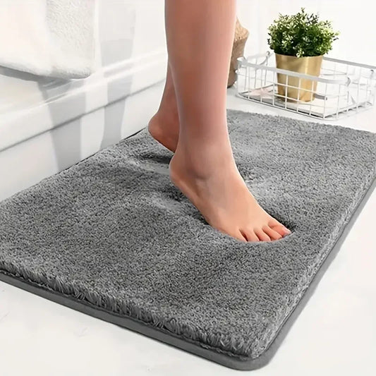 Anti-slip Bathroom Floor Mat in gray with plush texture, shown under bare feet for comfort and safety on wet bathroom floors.