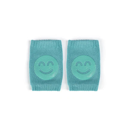 Non-slip baby knee pad in pink cotton with smiley face design, stacked with colorful pads for toddler protection during crawling.