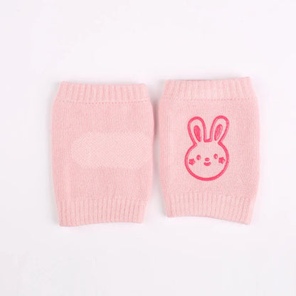 Non-slip baby knee pad in pink cotton with smiley face design, stacked with colorful pads for toddler protection during crawling.