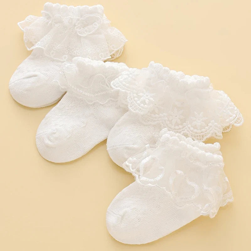 Lace baby girl socks in white with floral embroidery, made from soft combed cotton. Elegant princess-style socks for ages 0-8.