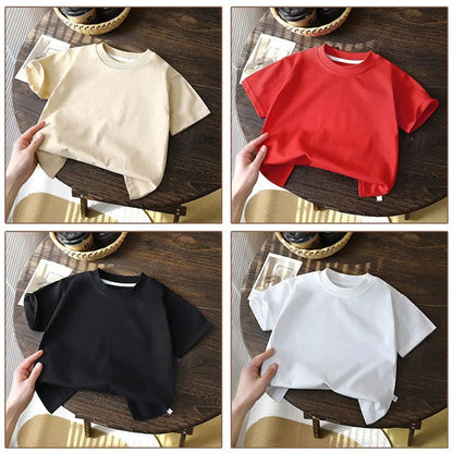 Solid cotton casual short sleeve T-shirts for kids in black, red, beige, and white colors, displayed on a wooden table.