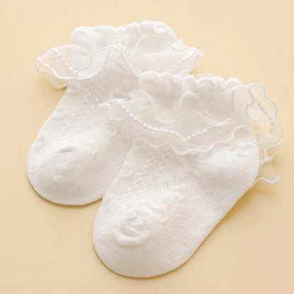 Lace baby girl socks in white with floral embroidery, made from soft combed cotton. Elegant princess-style socks for ages 0-8.