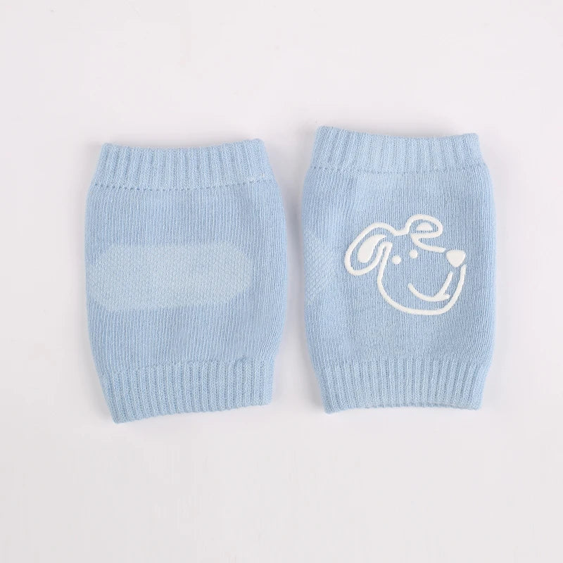 Non-slip baby knee pad in pink cotton with smiley face design, stacked with colorful pads for toddler protection during crawling.