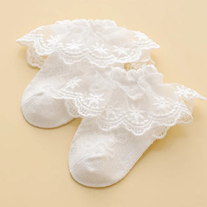 Lace baby girl socks in white with floral embroidery, made from soft combed cotton. Elegant princess-style socks for ages 0-8.